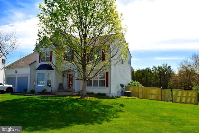 traditional-style house featuring an attached garage and central AC unit