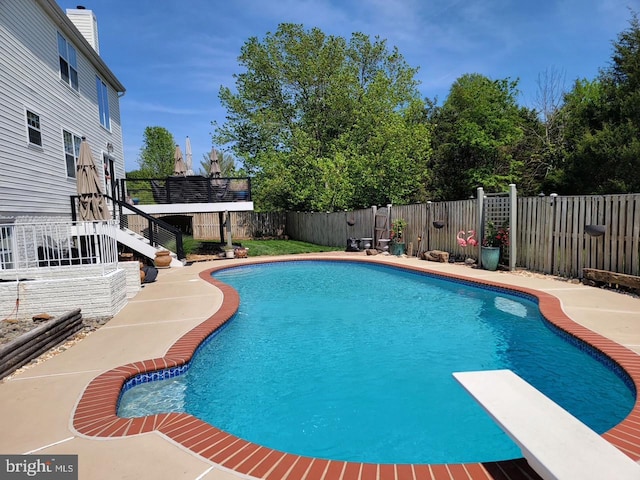 view of pool featuring stairway, a fenced backyard, a diving board, and a deck