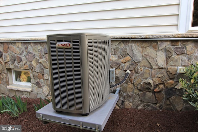 exterior details with stone siding and central air condition unit