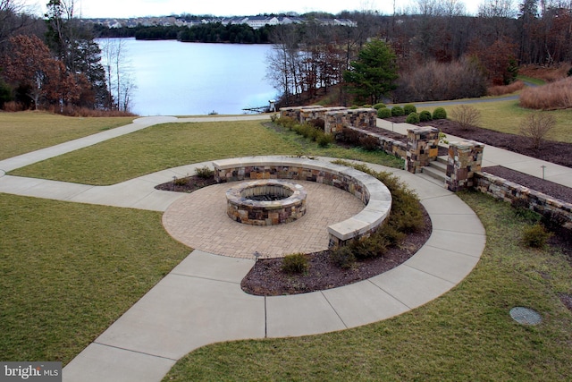 view of yard with an outdoor fire pit and a water view
