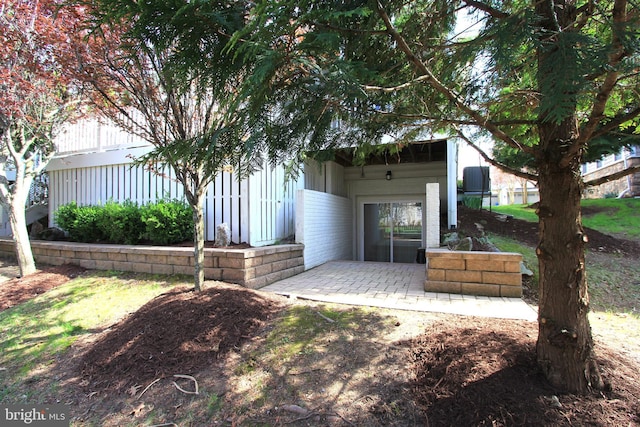 view of front of home with a patio area and brick siding