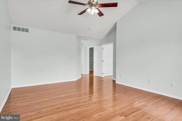 spare room with baseboards, light wood-style flooring, visible vents, ceiling fan, and high vaulted ceiling