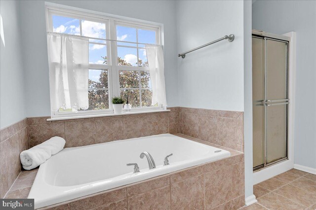 bathroom featuring a shower stall, plenty of natural light, and a garden tub