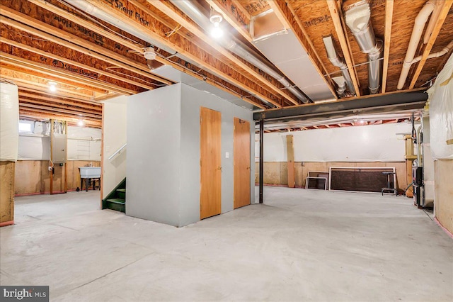 unfinished below grade area with a sink and electric panel