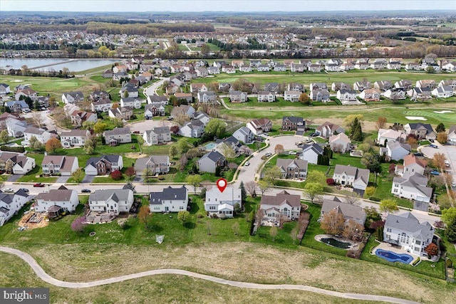 drone / aerial view with a residential view, view of golf course, and a water view