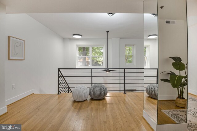 living area featuring an upstairs landing, wood finished floors, and baseboards