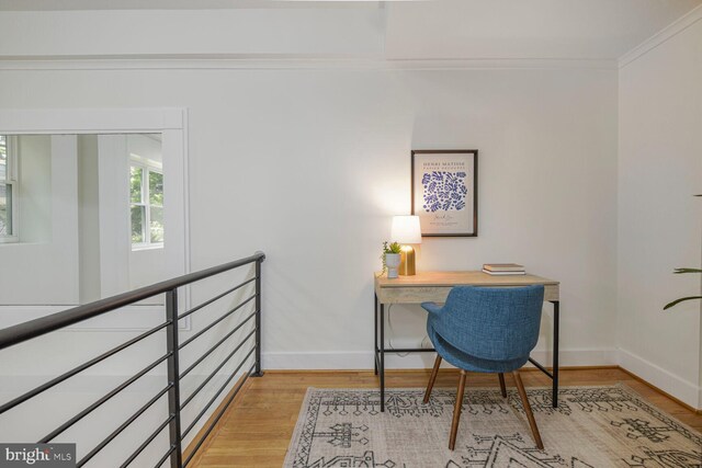 office with baseboards, light wood-type flooring, and crown molding