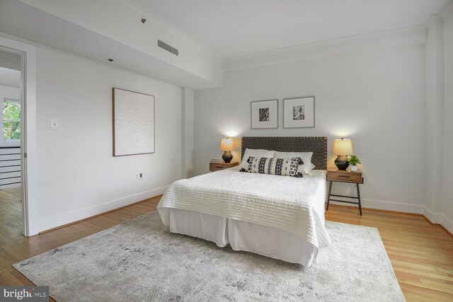 bedroom featuring crown molding, baseboards, and wood finished floors