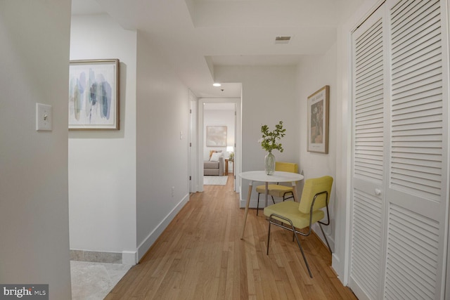 hall with baseboards and light wood-style flooring
