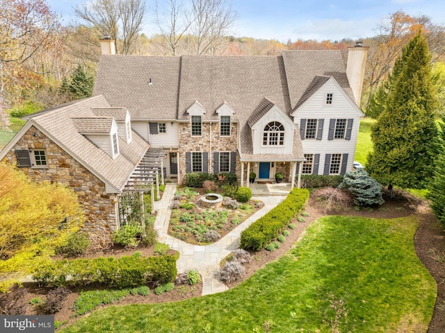607 Newtown Rd, Berwyn, PA 19312 - rear view of property with a yard, a chimney, stone siding, and an outdoor fire pit