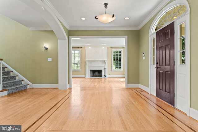 607 Newtown Rd, Berwyn, PA 19312 - foyer featuring crown molding, arched walkways, a fireplace, wood finished floors, and baseboards