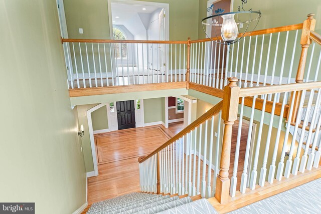 607 Newtown Rd, Berwyn, PA 19312 - stairway with baseboards, a high ceiling, wood finished floors, and a notable chandelier