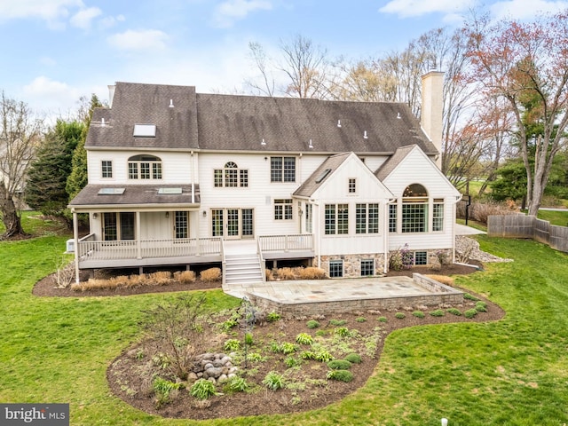 607 Newtown Rd, Berwyn, PA 19312 - rear view of house featuring a deck, a patio, a chimney, board and batten siding, and a yard