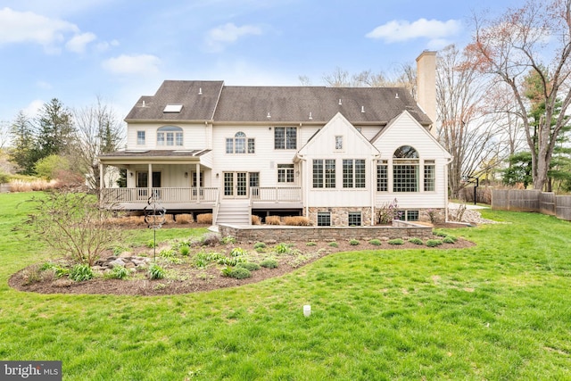 607 Newtown Rd, Berwyn, PA 19312 - back of house with board and batten siding, a chimney, a lawn, a deck, and fence