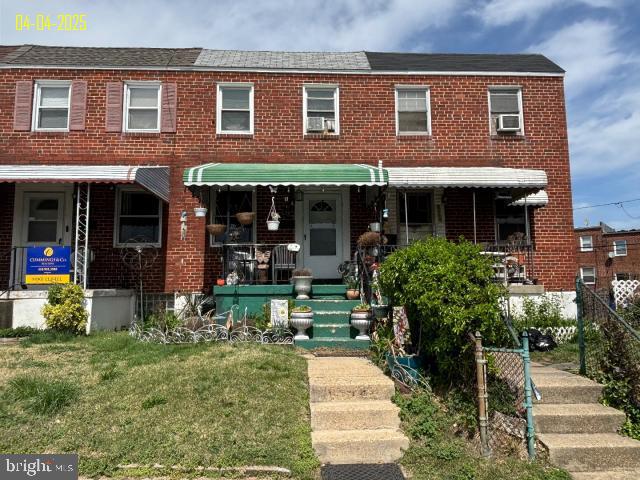 multi unit property with a front lawn and brick siding