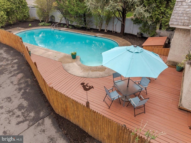 view of swimming pool with a fenced backyard, a fenced in pool, and a wooden deck