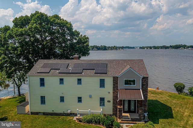 exterior space with a chimney, roof mounted solar panels, and a front yard