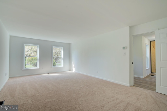 empty room featuring baseboards and carpet