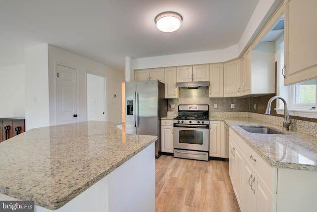 kitchen featuring a center island, a sink, under cabinet range hood, stainless steel appliances, and light wood-style flooring