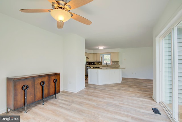 living room with baseboards, light wood finished floors, ceiling fan, and visible vents