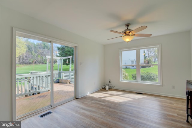interior space featuring a healthy amount of sunlight, visible vents, and wood finished floors