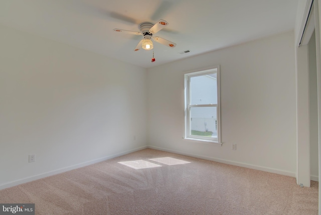 unfurnished room featuring baseboards, visible vents, ceiling fan, and carpet