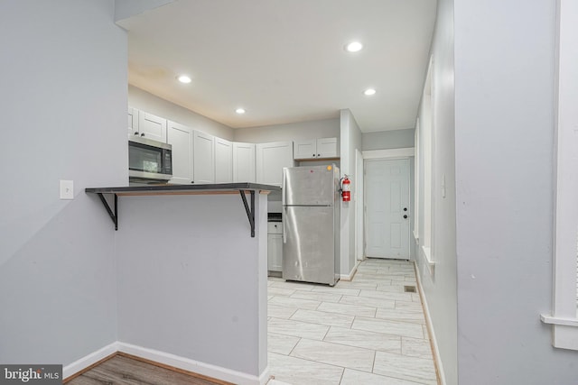 836 State St, Camden, NJ 08102 - kitchen with white cabinets, dark countertops, baseboards, recessed lighting, and appliances with stainless steel finishes