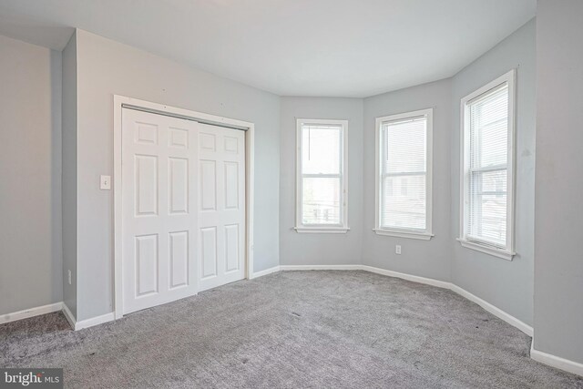 836 State St, Camden, NJ 08102 - unfurnished bedroom with baseboards, carpet floors, multiple windows, and a closet
