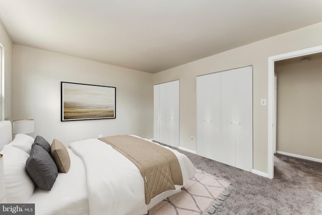 carpeted bedroom with multiple closets and baseboards