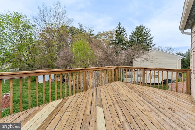 wooden terrace featuring a lawn
