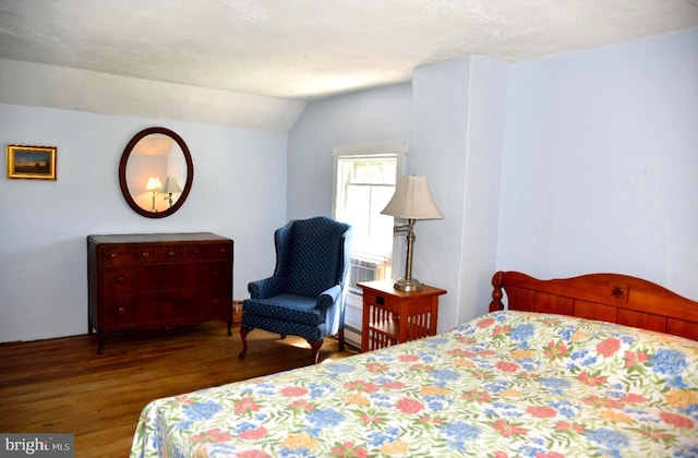 bedroom with wood finished floors and vaulted ceiling