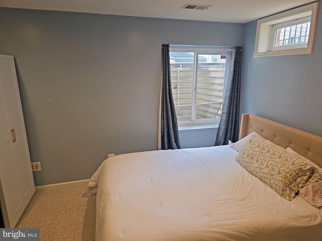 carpeted bedroom with visible vents and baseboards