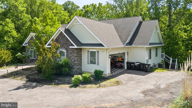 6707 Burch Hill Rd, Brandywine, MD 20613 - view of front of house with an attached garage, asphalt driveway, roof with shingles, stone siding, and central AC unit
