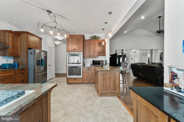 6707 Burch Hill Rd, Brandywine, MD 20613 - kitchen featuring stainless steel appliances, a kitchen breakfast bar, brown cabinetry, dark stone countertops, and recessed lighting
