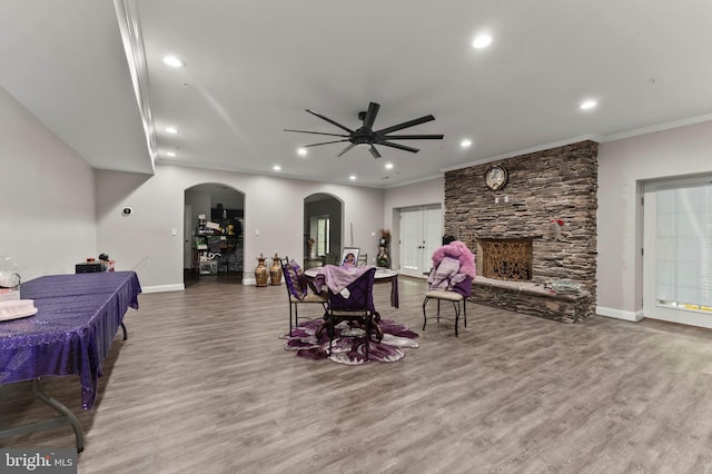 6707 Burch Hill Rd, Brandywine, MD 20613 - living room featuring a stone fireplace, ceiling fan, wood finished floors, ornamental molding, and baseboards