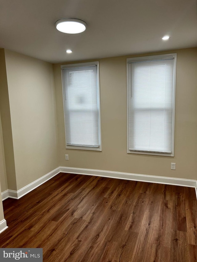 spare room with recessed lighting, dark wood-style flooring, and baseboards
