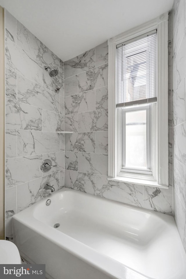 full bath featuring toilet, plenty of natural light, and bathing tub / shower combination
