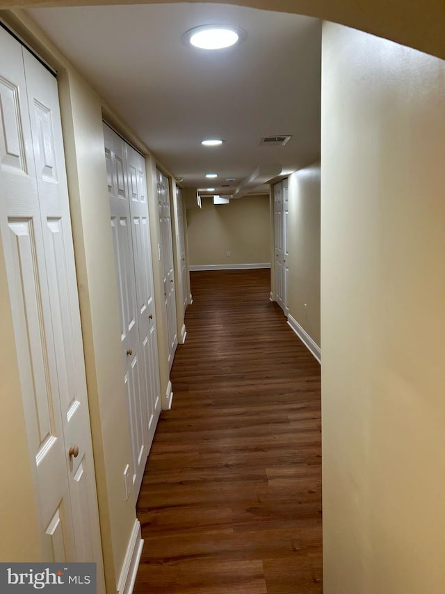 hallway with dark wood-style floors, recessed lighting, visible vents, and baseboards