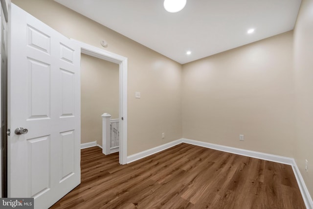 empty room with recessed lighting, wood finished floors, and baseboards