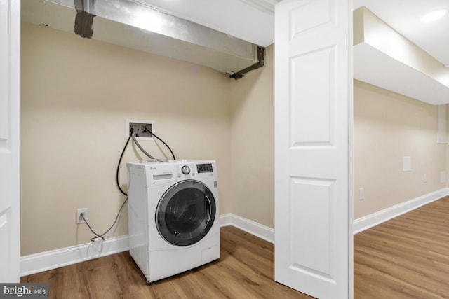 laundry area with wood finished floors, washer / clothes dryer, laundry area, and baseboards