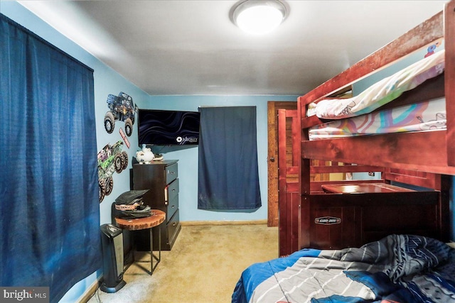 bedroom featuring baseboards, wet bar, and carpet floors