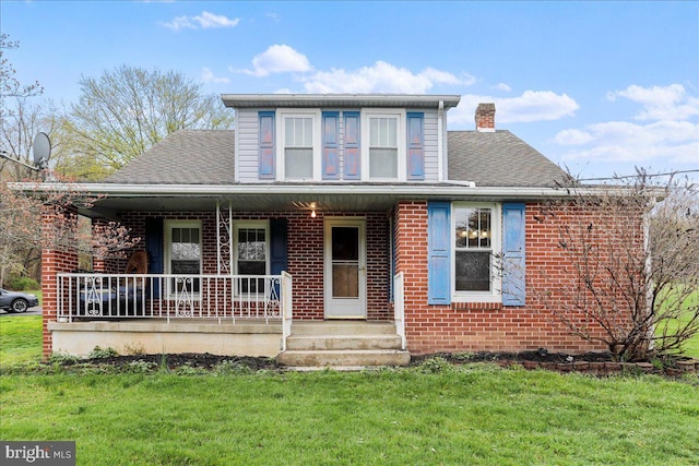 view of front of property with brick siding, a front lawn, covered porch, and roof with shingles