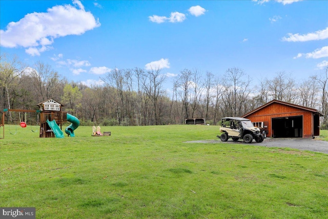 view of yard featuring a detached garage, an outdoor structure, and a playground