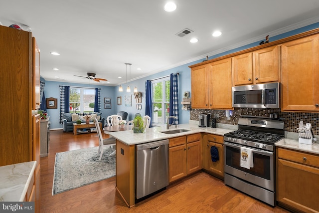 105 Cresthaven Ln, Dover, DE 19901 - kitchen with appliances with stainless steel finishes, a sink, open floor plan, a peninsula, and decorative backsplash