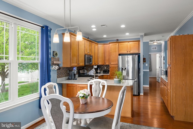 105 Cresthaven Ln, Dover, DE 19901 - kitchen with appliances with stainless steel finishes, ornamental molding, a peninsula, backsplash, and light countertops