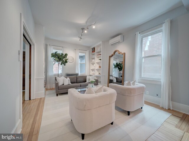 1234 Monroe St NE, Washington, DC 20017 - living area with light wood-type flooring, an AC wall unit, baseboards, and built in shelves