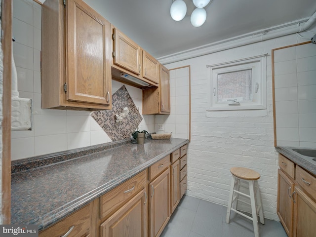 1234 Monroe St NE, Washington, DC 20017 - kitchen with brick wall, tasteful backsplash, tile patterned flooring, and dark stone countertops