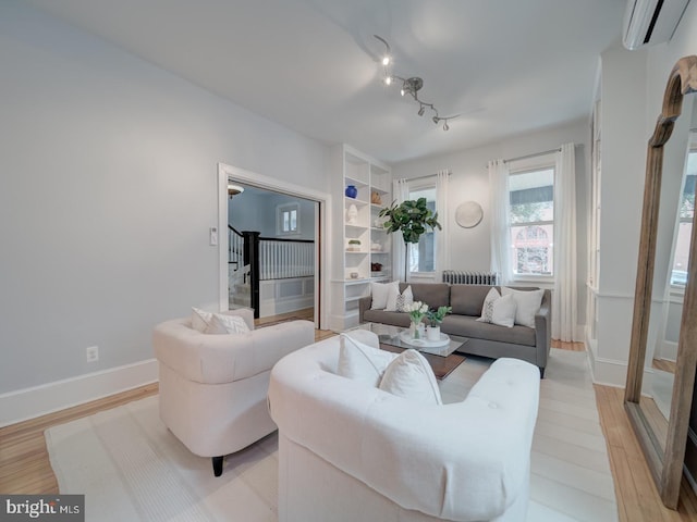 1234 Monroe St NE, Washington, DC 20017 - living room featuring a wall mounted AC, light wood-type flooring, baseboards, and stairs
