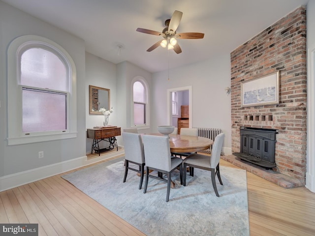 1234 Monroe St NE, Washington, DC 20017 - dining room with a wood stove, light wood-type flooring, ceiling fan, and baseboards