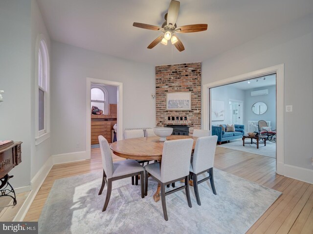 1234 Monroe St NE, Washington, DC 20017 - dining room with baseboards, a brick fireplace, light wood-type flooring, and a ceiling fan